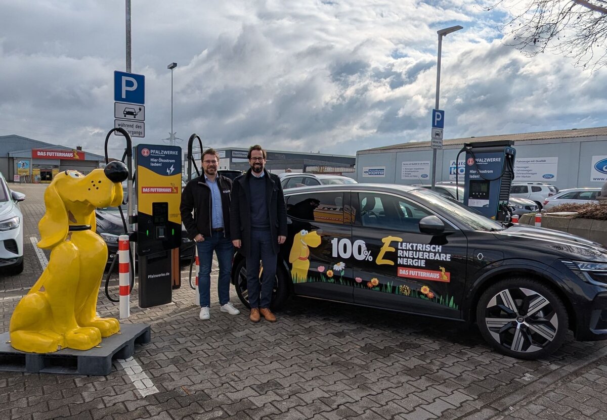 Zwei Projektverantwortliche der beiden Unternehmen präsentieren an einer Ladesäule vor Futterhaus-Markt die Kooperation zwischen Pfalzwerke und Das Futterhaus | © Pfalzwerke